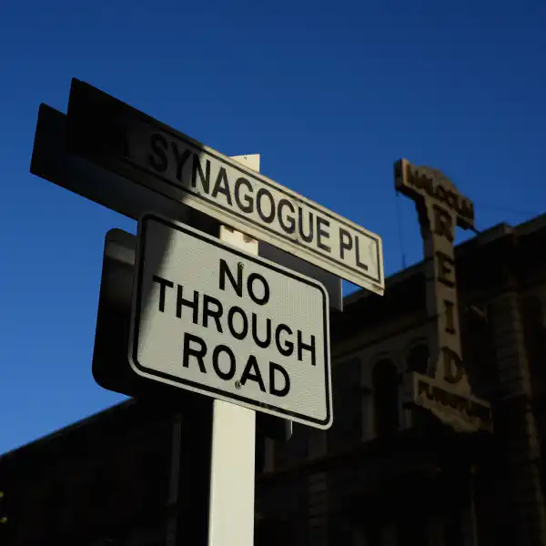 A street sign, saying 'Synagogue Place' and 'No through road'