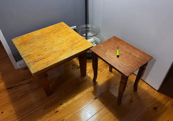 Two tables, viewed from above. One is slightly smaller than the other and has a screwdriver resting on it