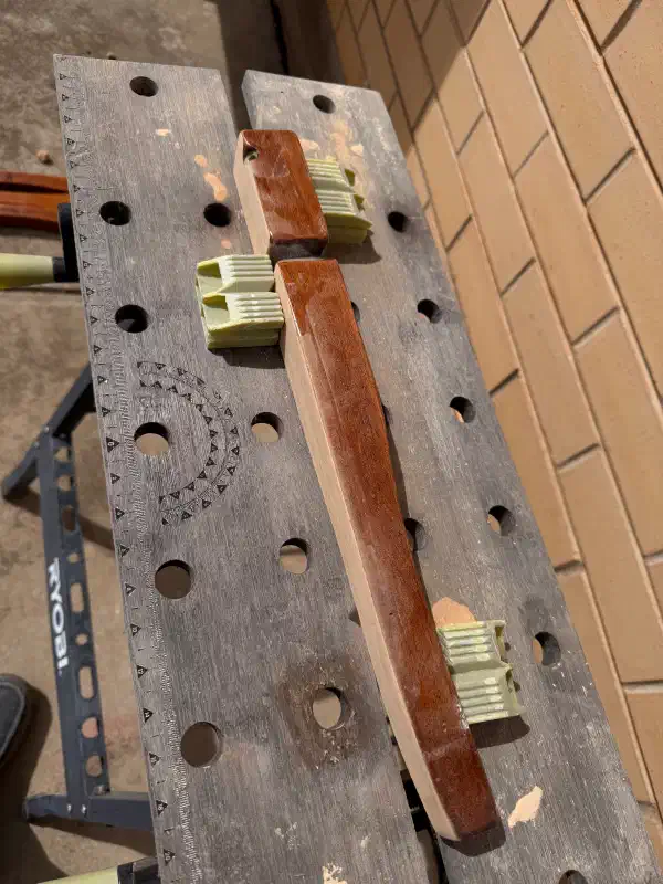 Table leg on sawhorse, held in place with clamps