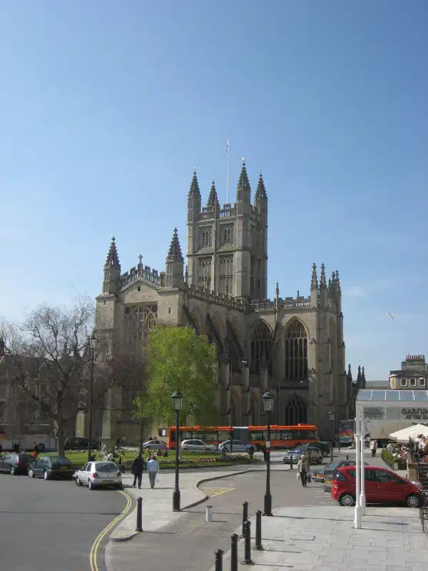 A view of an abbey, from around 100m away. There is a street and cars in the foreground.