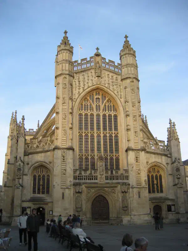 The front of an abbey, gothic styling, built with tan-coloured stone